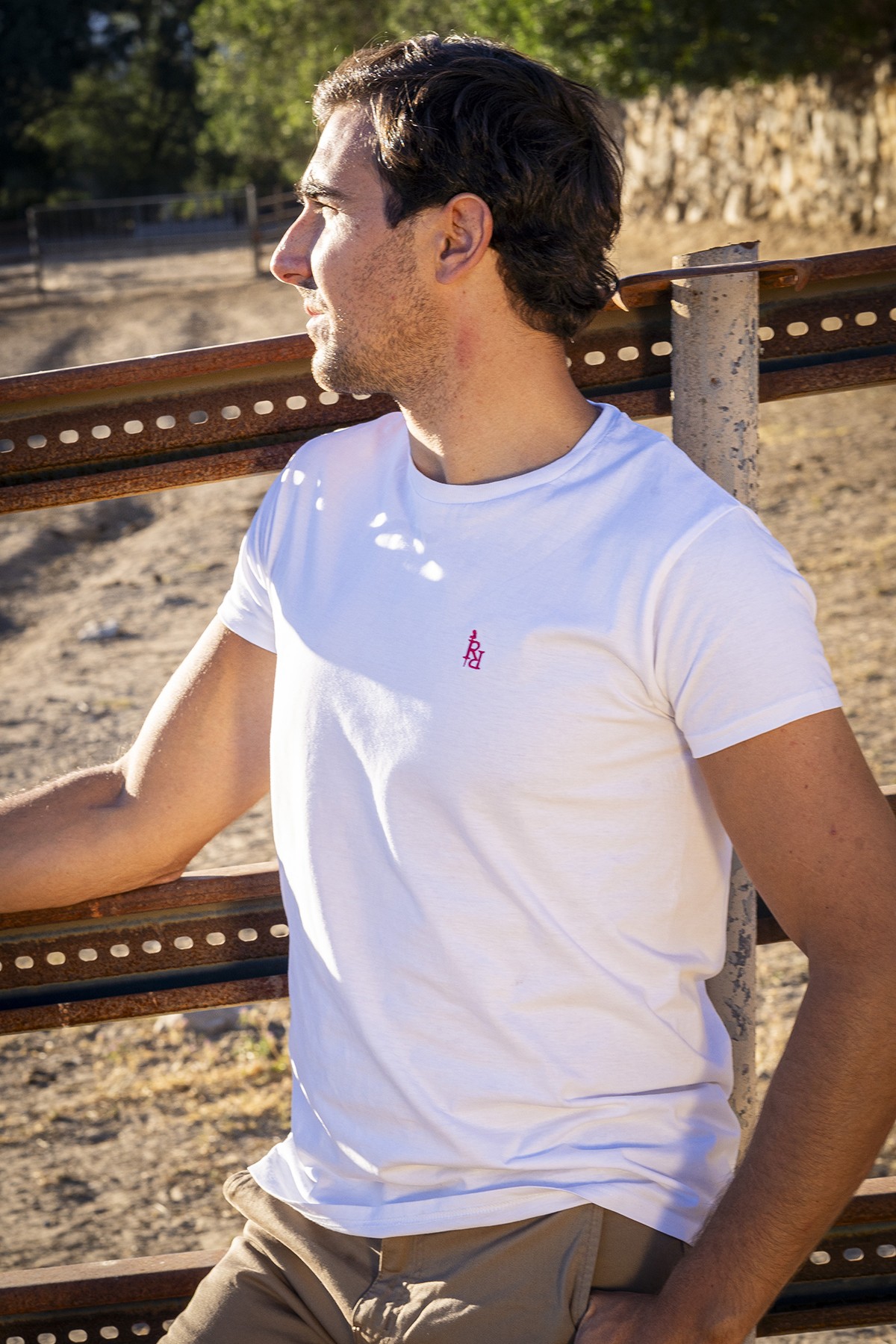 Camiseta unisex blanca logo bordado en fucsia.